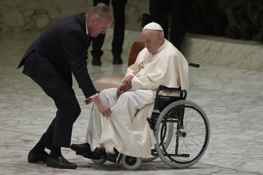 El papa Francisco consulta su reloj mientras asiste a una audiencia con peregrinos