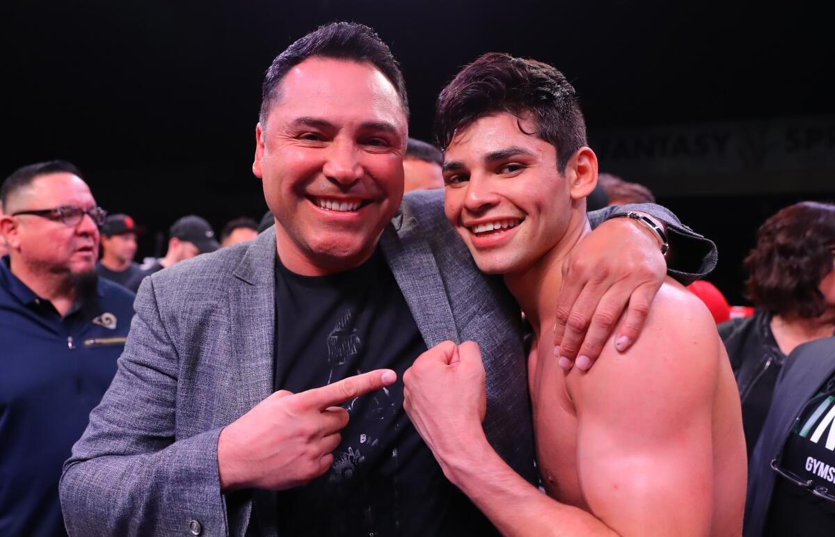 Ryan Garcia celebrates with Oscar De La Hoya after his victory over Jose Lopez on March 30.