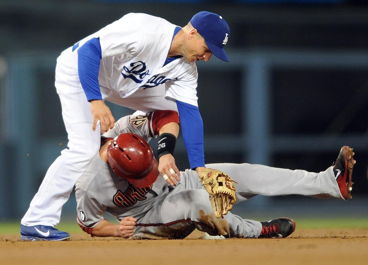 Dodgers second baseman Mark Ellis, top, collides with Arizona's Miguel Montero after turning a double play during the second inning of the Dodgers' 5-3 win Tuesday.