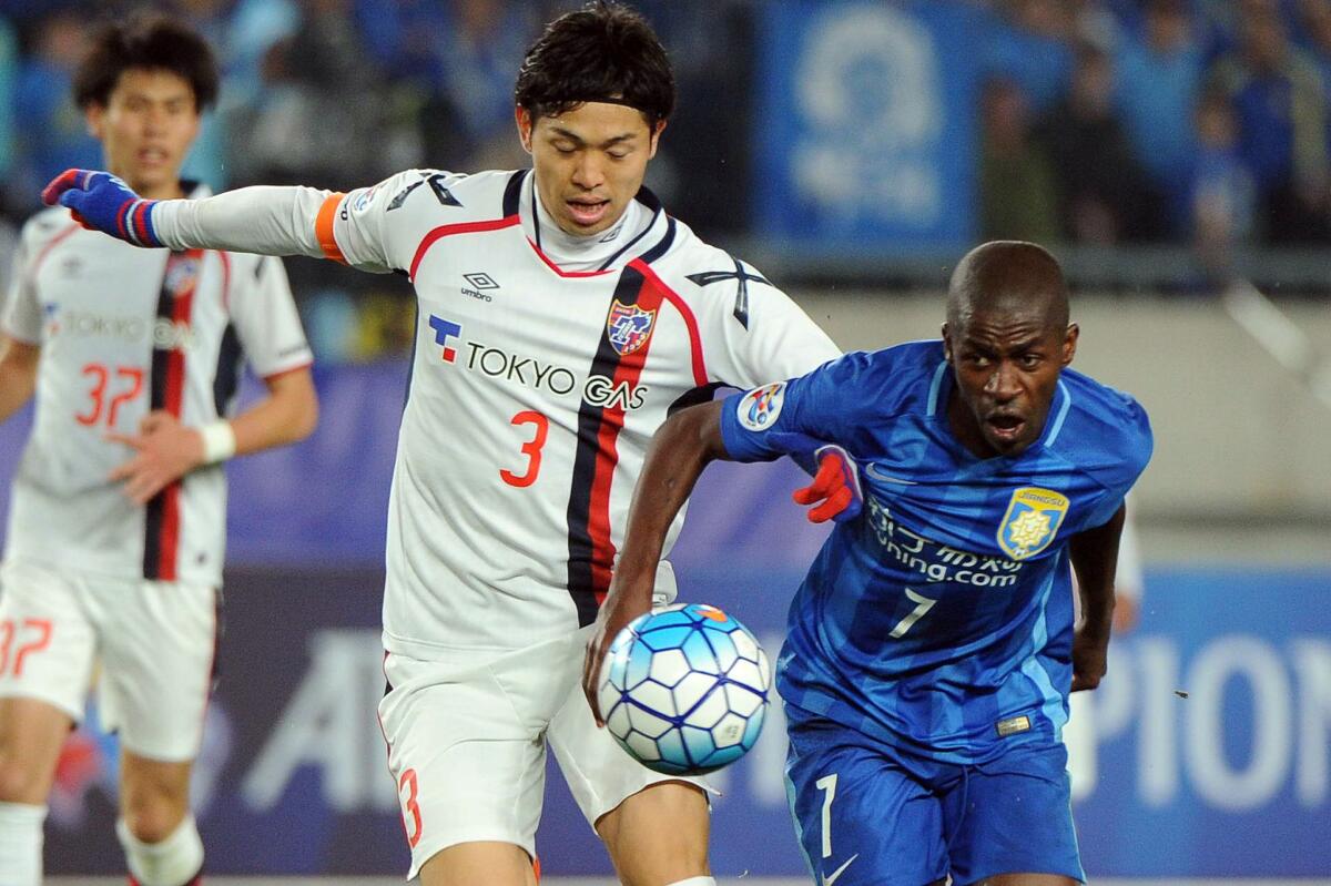 Ramires Santos of China's Jiangsu FC, right, competes for the ball with Morishige Masato of Japan's FC Tokyo during a soccer match on April 6.