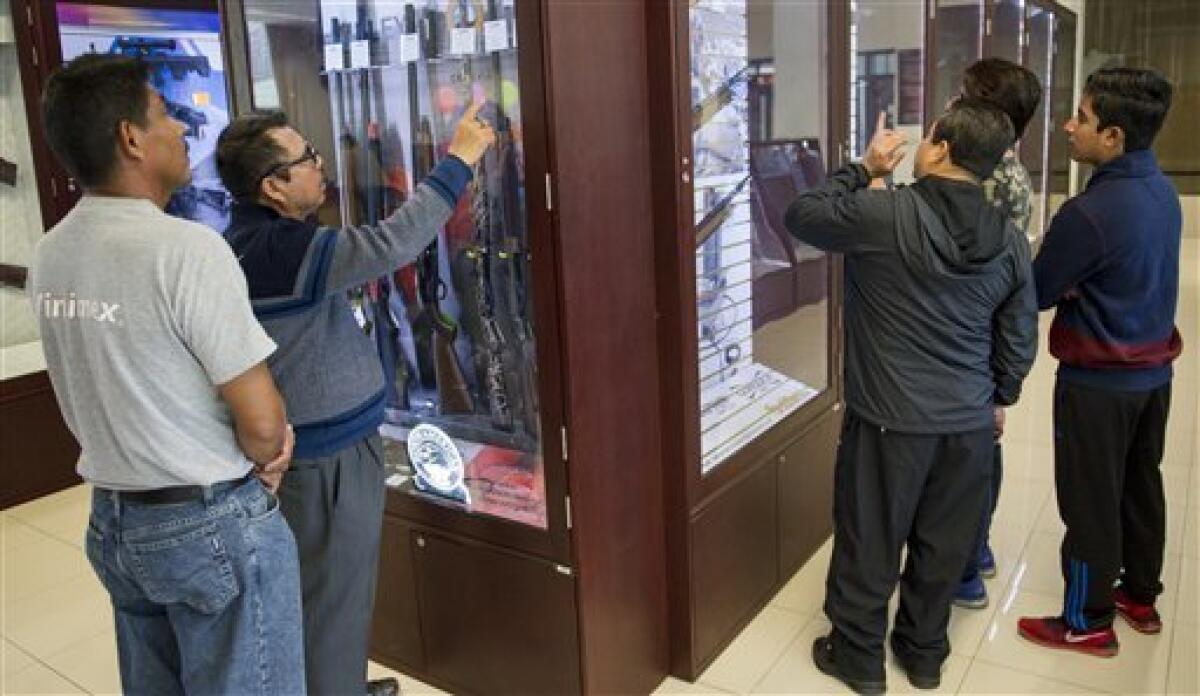 En esta imagen, tomada el 15 de julio de 2016, clientes observan las armas a la venta en la única tienda de armas en México, en la ciudad de México. Quienes entran deben dejar sus celulares, tabletas o cámaras; quitarse gorras y pasar a través de un detector de metal.