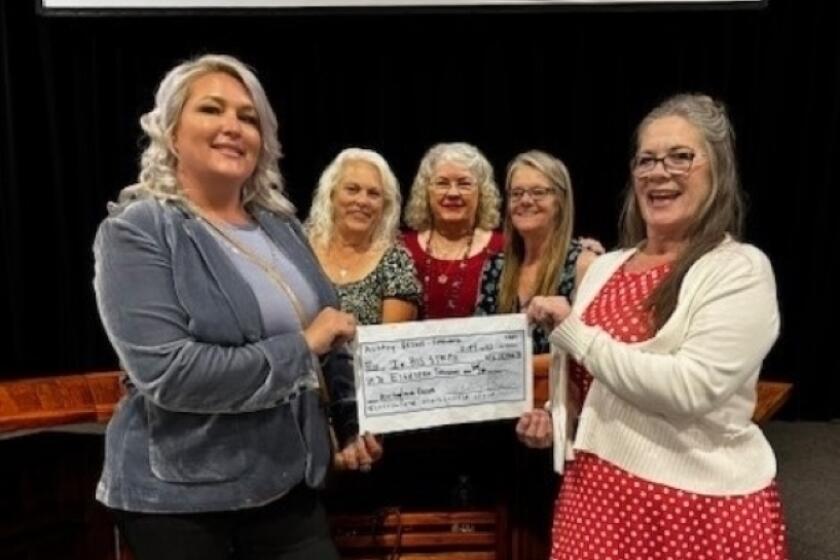 Audrey Briggs, left, presenting a check to Dolores Mortier, Carol Huff, April Woodward and Christine Golyer.