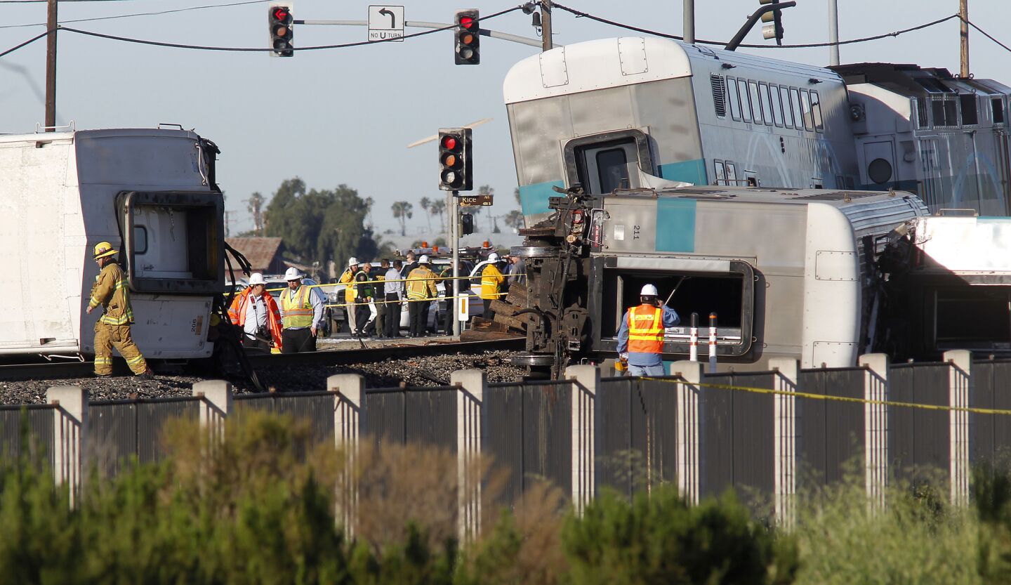 Firefighters inspect a Metrolink train car that derailed in Oxnard early Tuesday.