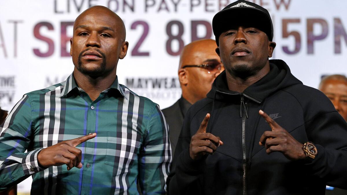 Boxers Floyd Mayweather Jr., left, and Andre Berto strike a pose during their news conference on Wednesday in Las Vegas.