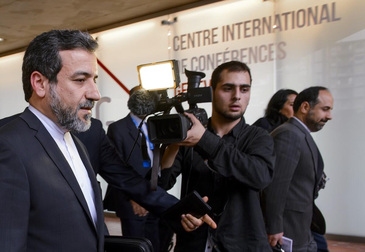 Iran's deputy foreign minister, Abbas Araghchi, left, leaves the media center after the start of two days of closed-door nuclear talks on Tuesday at the United Nations offices in Geneva.