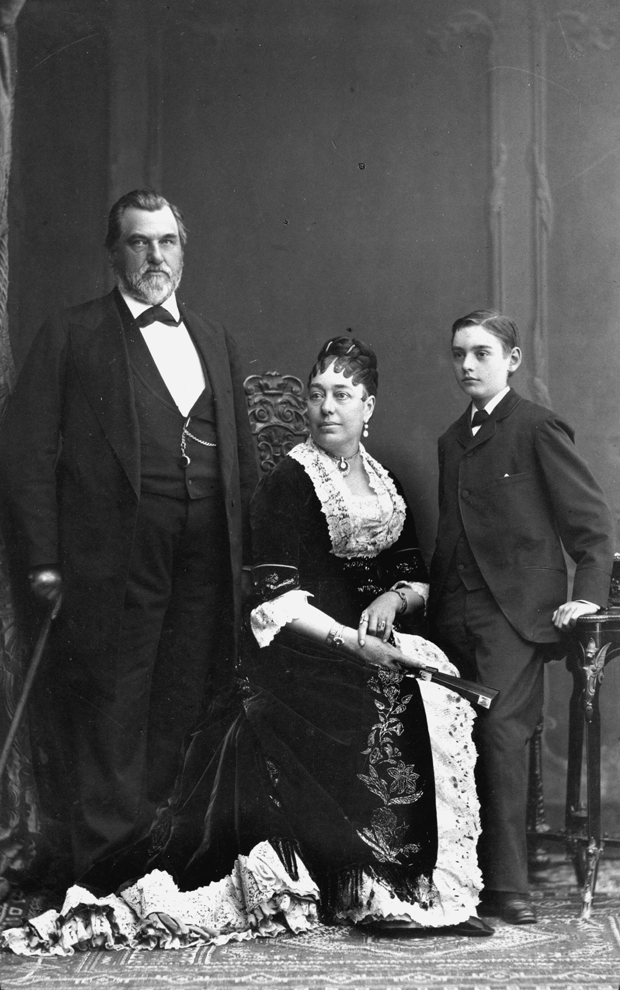 A black-and-white photo of a man, woman and young boy.