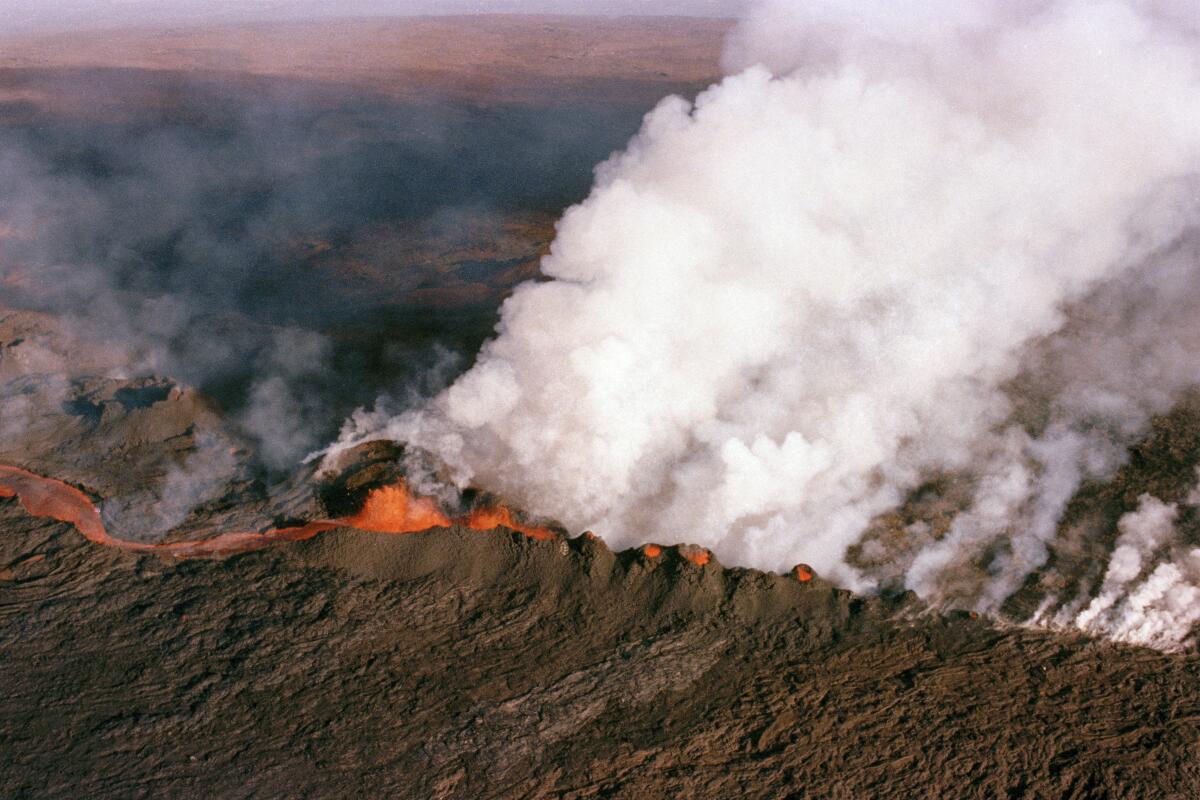 FILE - A gaseous cloud rises from the crater of Mauna Loa, center, on the big island of Hawaii, April 4, 1984. The ground is shaking and swelling at Mauna Loa, the largest active volcano in the world, indicating that it could erupt. Scientists say they don't expect that to happen right away but officials on the Big Island of Hawaii are telling residents to be prepared in case it does erupt soon. (AP Photo/John Swart, File)
