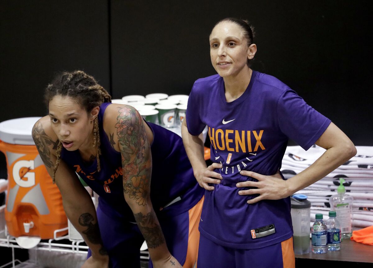 FILE - Phoenix Mercury's Brittney Griner, left, watches practice with teammate Diana Taurasi on Thursday, May 10, 2018, in Phoenix. Since arriving a Moscow airport in mid-February, Griner has been detained by police after they reported finding vape cartridges allegedly containing cannabis oil in her luggage. Still in jail, she is awaiting trial next month on charges that could bring up to 10 years in prison. Taurasi also spent years playing in Russia for UMKC Ekaterinburg owner Shabtai Kalmanovich, and spoke of luxurious living conditions and the lavish trips he would provide. (AP Photo/Matt York, File)