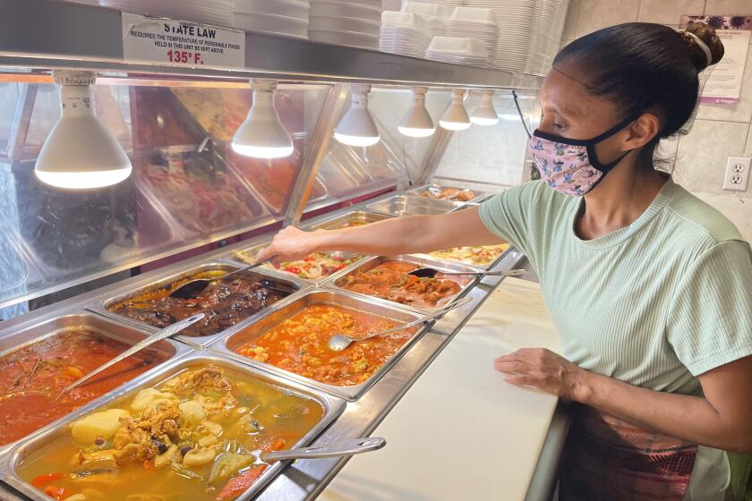 Maribel Celidón, empleada de Mayan Restaurant, muestra algunos de los platillos.