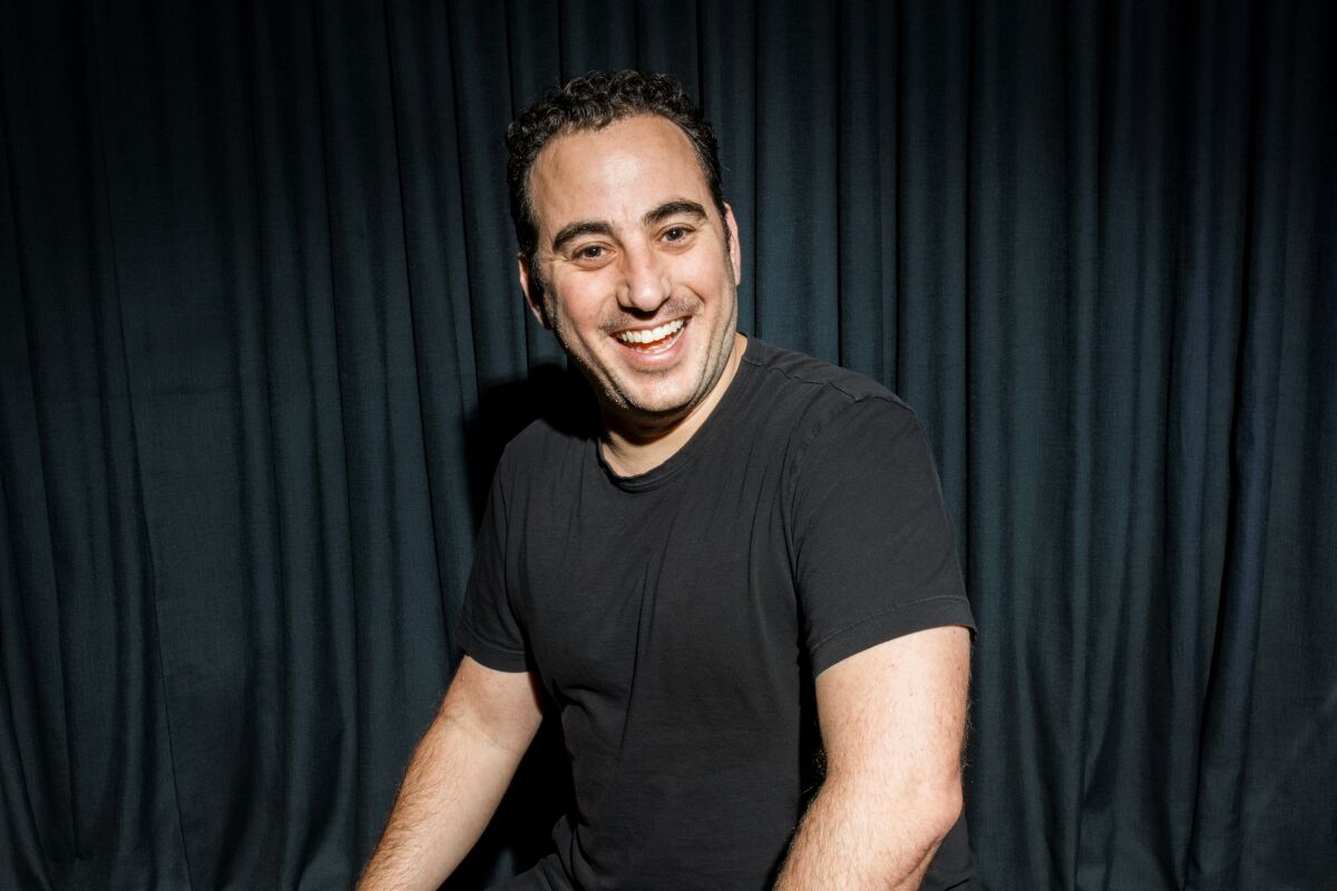 A photograph of chef Daniel Rose smiling in a black tee shirt.
