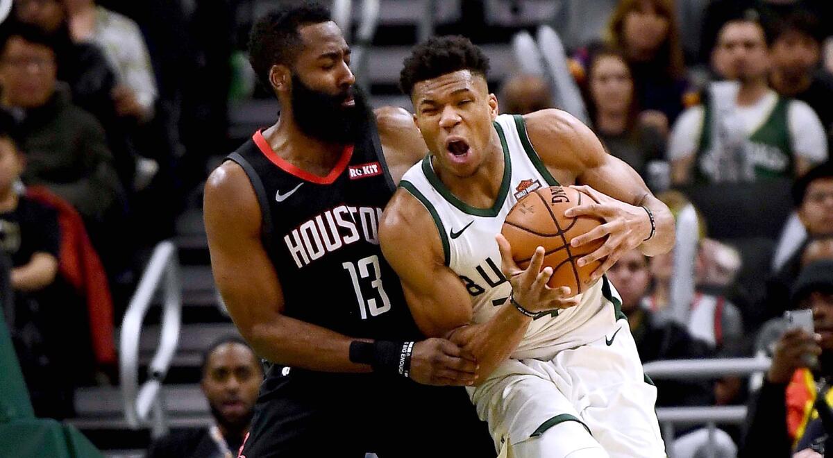 Rockets guard James Harden tries to hold his ground against Bucks forward Giannis Antetokounmpo during a game on March 26, 2019.