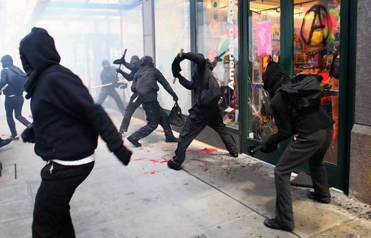 Protesters break windows of downtown Seattle businesses during a May Day rally Tuesday.