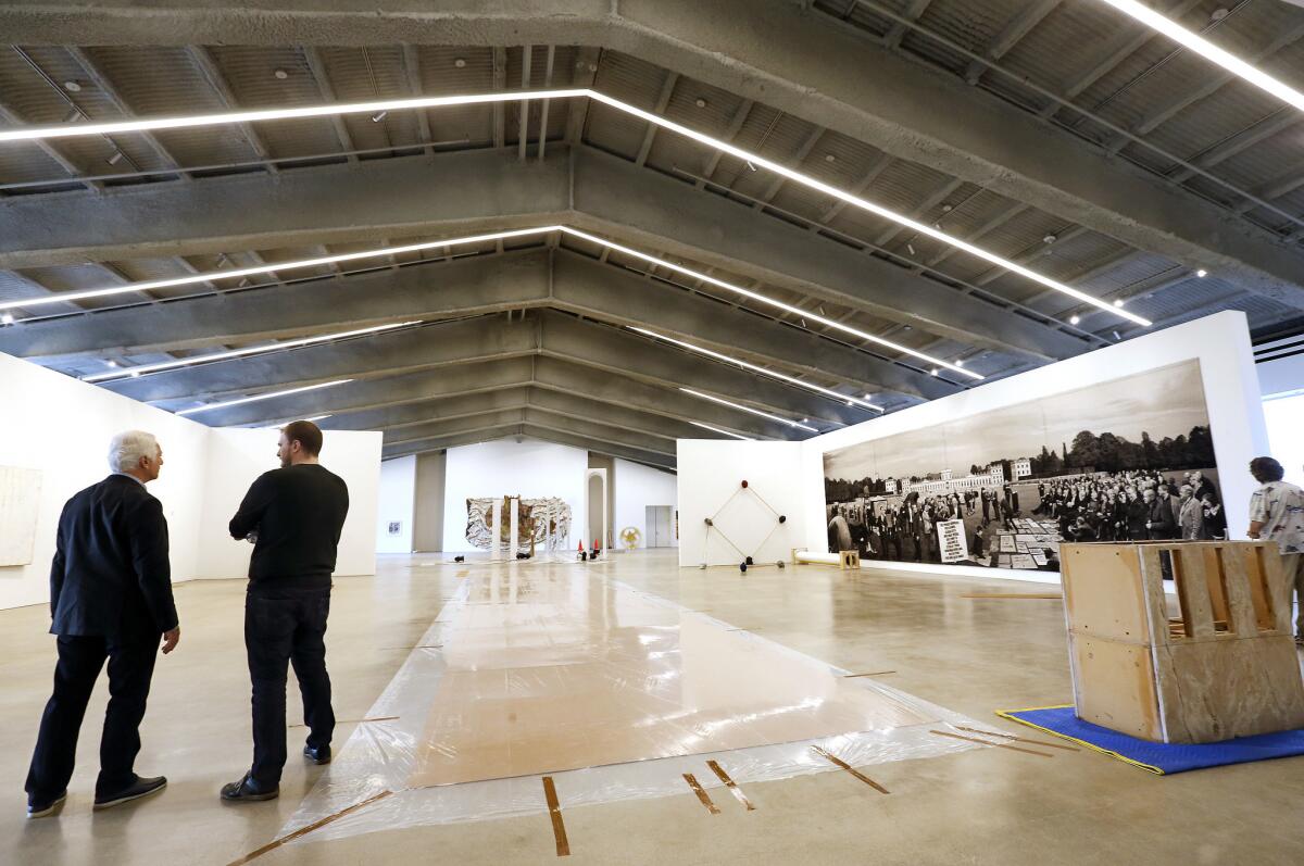 Maurice Marciano, left, during art installation before the foundation opening in 2017.