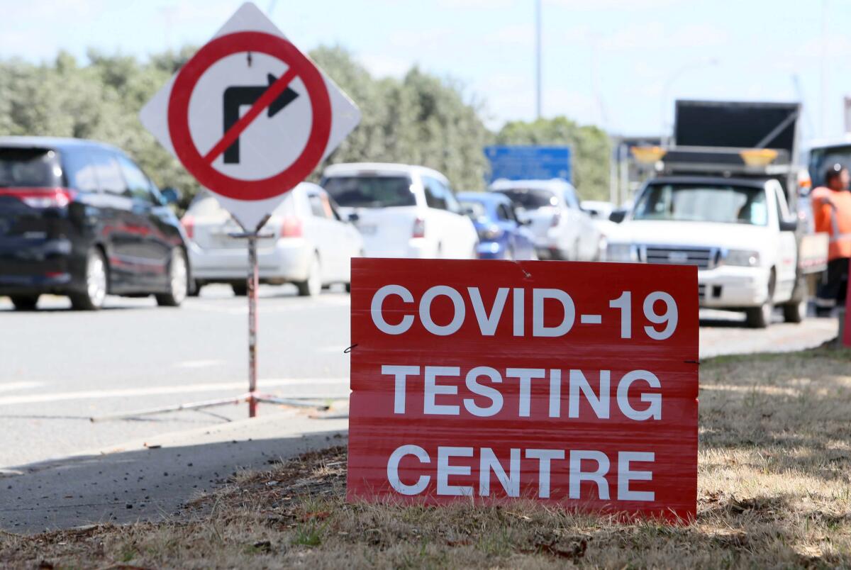A coronavirus testing site with cars waiting in a line.