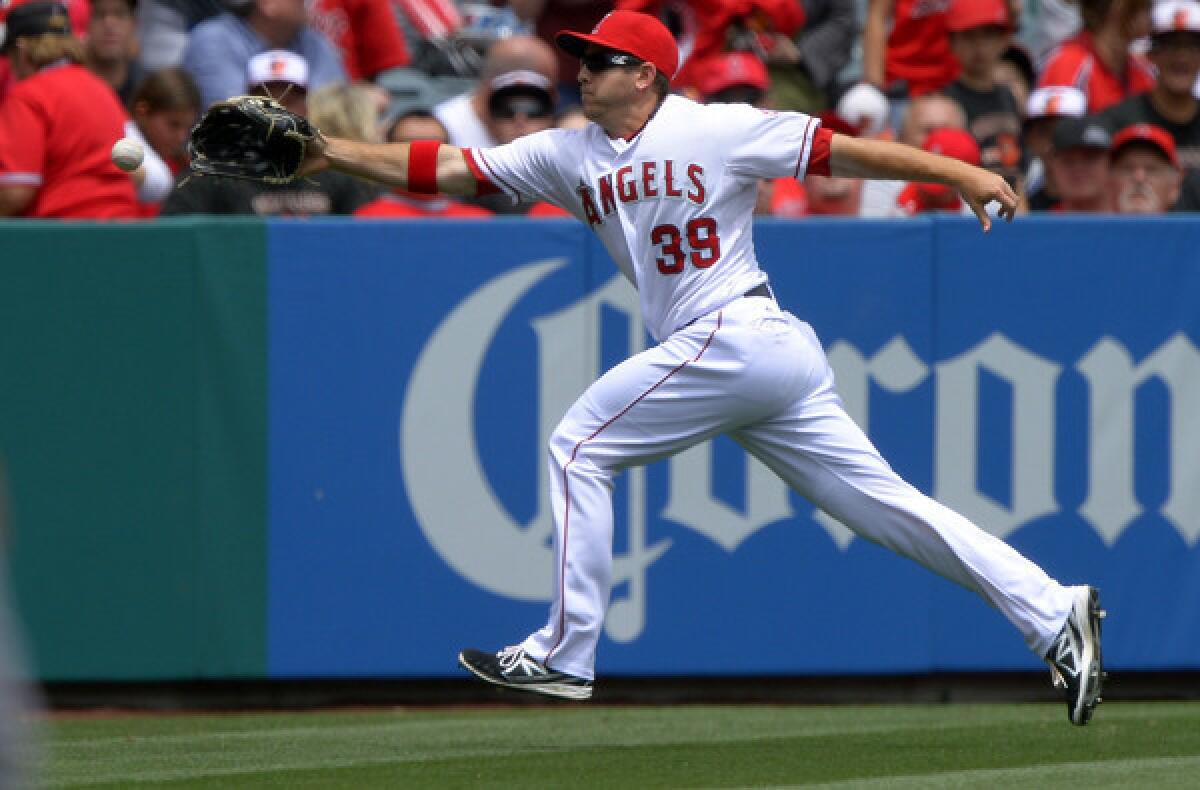 Angels left fielder J.B. Shuck can't reach a ball hit for a double by Baltimore's Nate McLouth in the first inning Sunday.