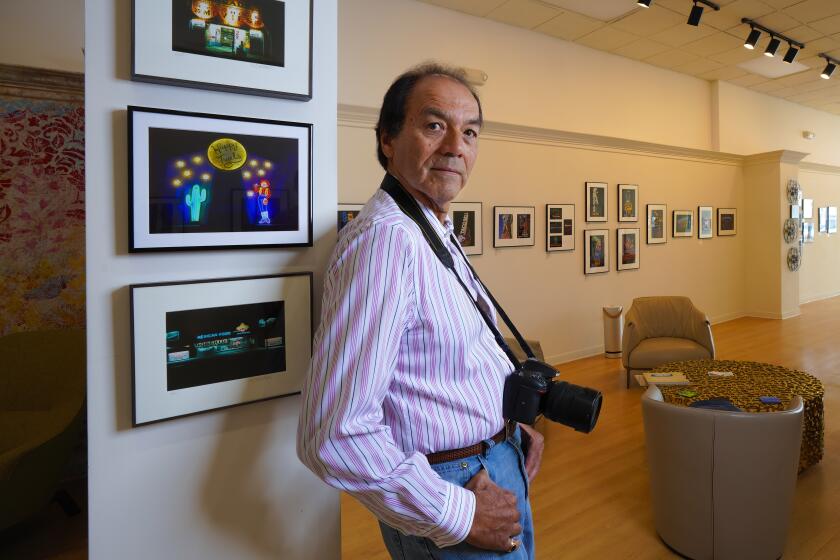San Diego, CA - August 02: At the BFree Studio in La Jolla on Tuesday, Aug. 2, 2022 in San Diego, CA., Richard Ybarra stands among several of his photographs. Ybarra, whose new exhibition of neon-art photography is on exhibit at the BFree Studio gallery. The exhibit is called "Lights, Night: Neon, Photographs That Glow." (Nelvin C. Cepeda / The San Diego Union-Tribune)
