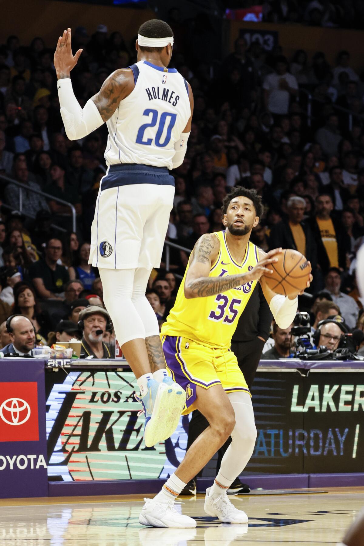 Lakers forward Christian Wood pump-fakes Mavericks forward Richaun Holmes into the air.