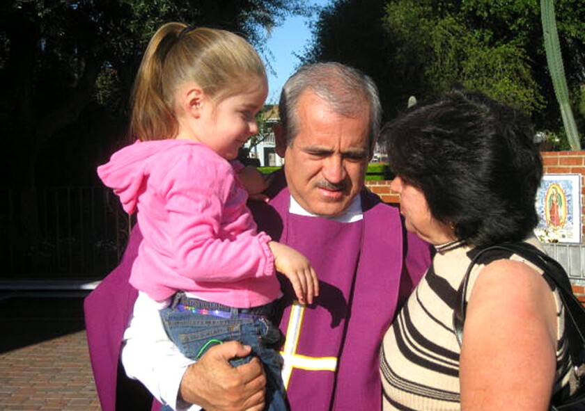Father Francisco Valdovinos stands with parishioners.