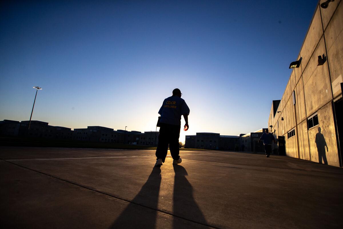 Luke Scott walks in the yard at Mule Creek State Prison in Ione, California at sunset.