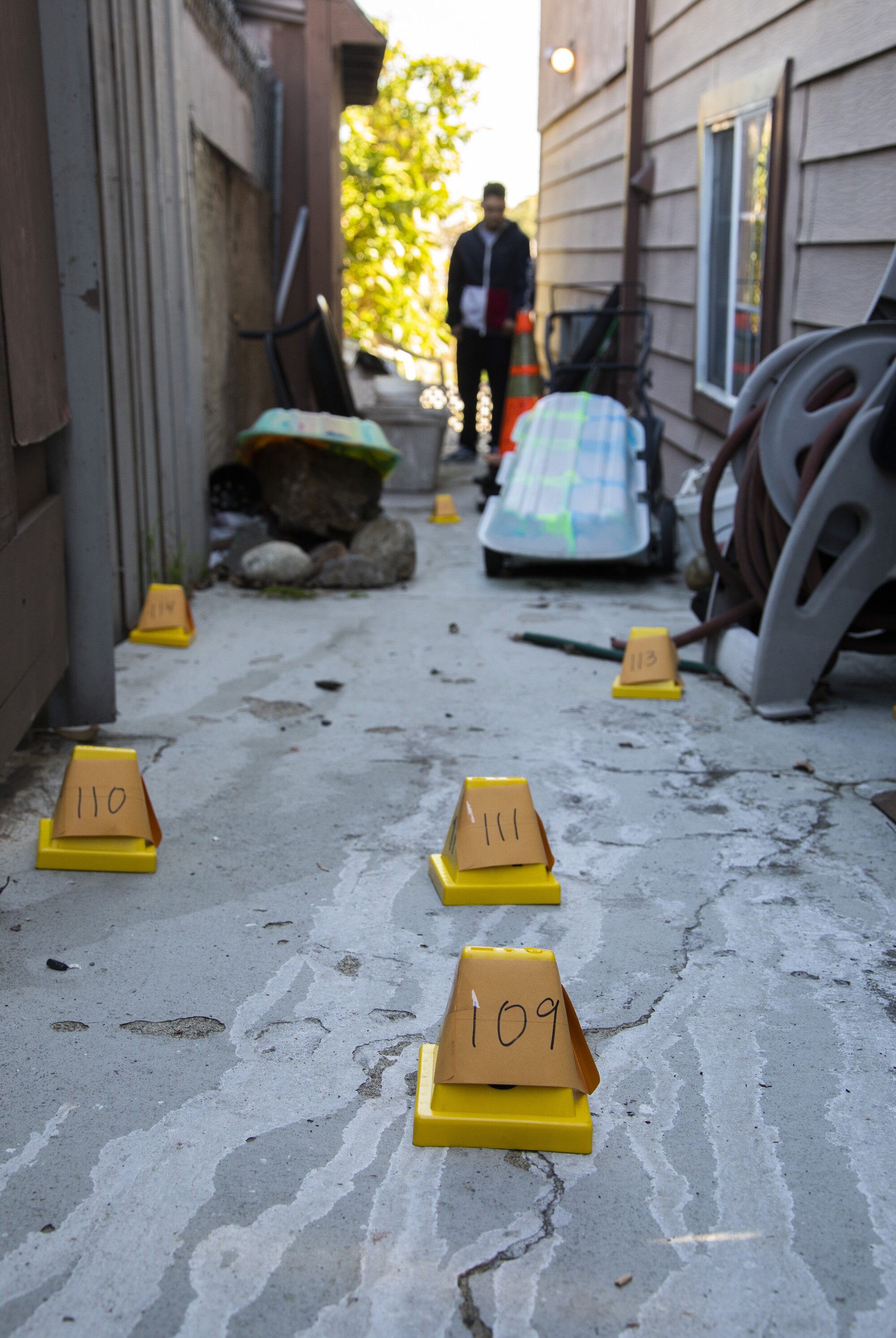 Yellow pylons are used as evidence markers near a home