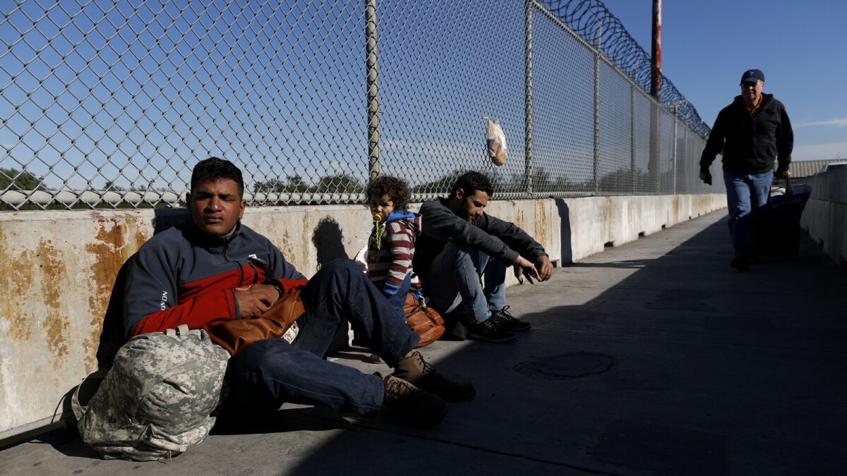 MATAMOROS, TAMAULIPAS -- WEDNESDAY, NOVEMBER 14, 2018: Political asylum seekers Elvis Gonzalez, 23, of Havana, Cuba, Robert Richard Braganca, of Rio De Janero, Brazil, and son Mario, 18-months, camp out on the Matamoros and Brownsville International Bridge in Matamoros, Tamaulipas, on Nov. 14, 2018. Gonzalez says he was asked to pay $1000 U.S. by a Mexican official for permission to stay on the bridge. He refused payment. (Gary Coronado / Los Angeles Times)