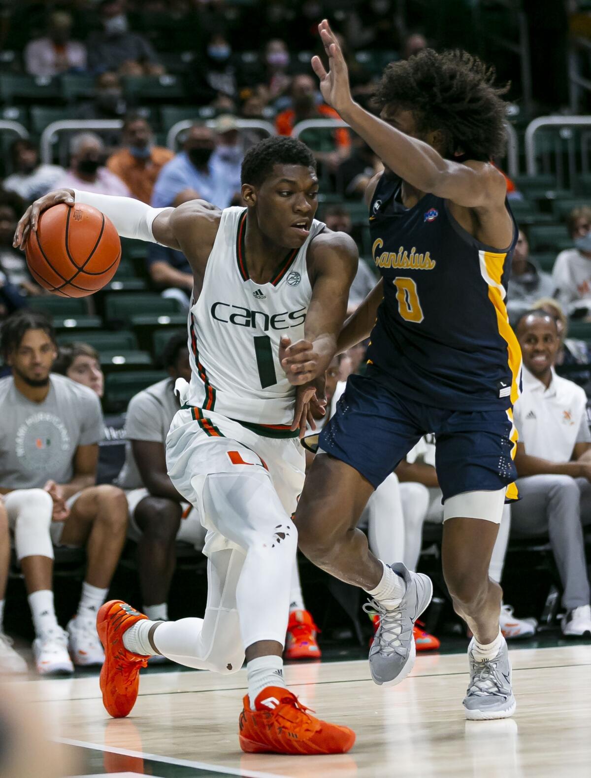 Miami forward Anthony Walker (1) looks to get past Canisius guard Akrum Ahemed (0) during the second half of an NCAA college basketball game, Tuesday, Nov. 9, 2021, in Coral Gables, Fla. (Matias J. Ocner/Miami Herald via AP)