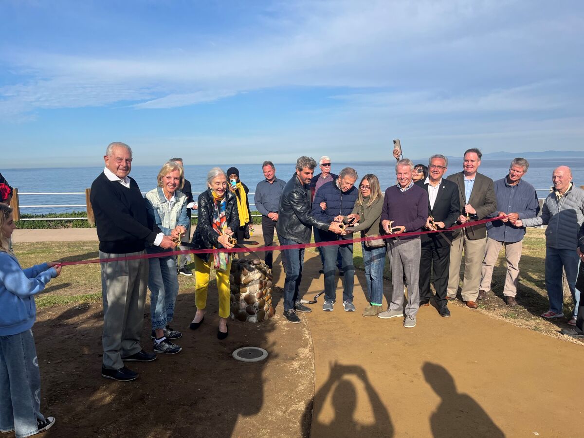 Members of the La Jolla Parks & Beaches group and others help cut the ribbon on the Scripps Park Picnic Grove.