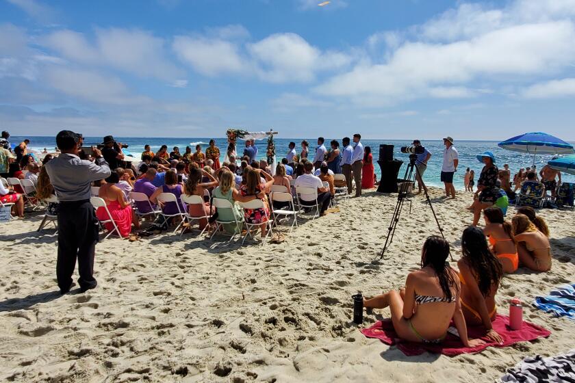 A wedding at Windansea Beach July 10, with several beachgoers nearby.