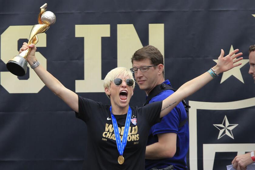 Megan Rapinoe hoists the World Cup trophy during a public celebration at L.A. Live's Microsoft Square on July 7, 2015.