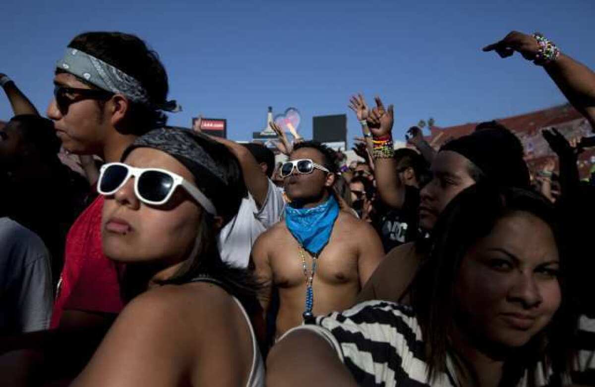 Vanessa de la Torre (left) and Vrome Villajin (blue scarf) watch to a performer during the Electric Daisy Carnival at the Coliseum.
