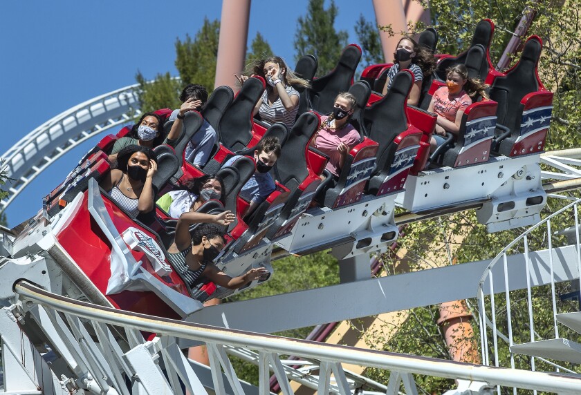 People ride a roller coaster at Six Flags Magic Mountain