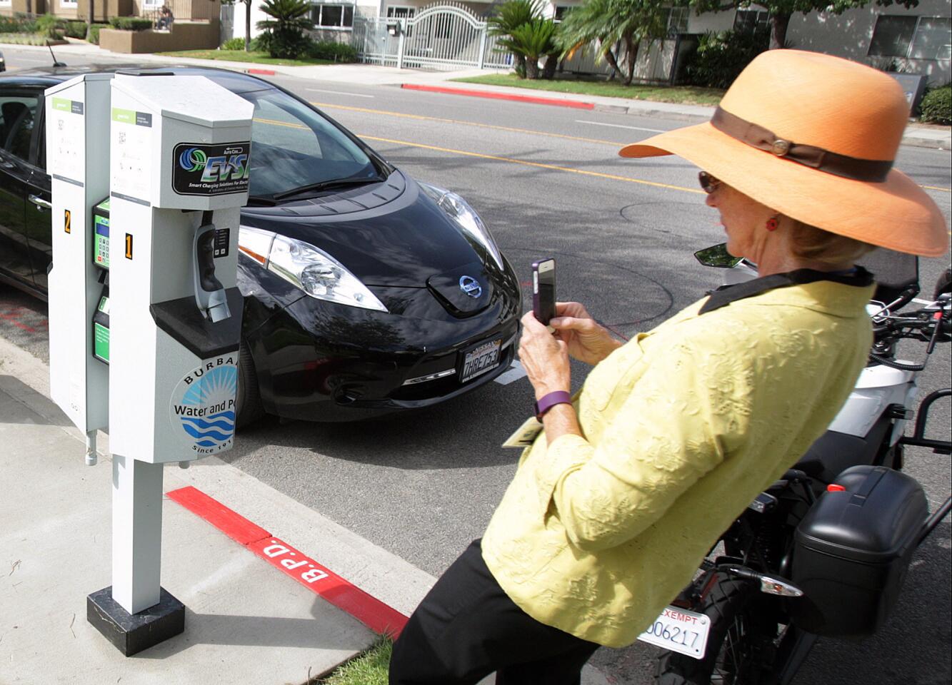 Burbank Councilwoman Emily Gabel-Luddy takes a picture of an EV charging station at a demonstration and ribbon cutting for one of eight dual-charger electric-vehicle charging station on Buena Vista Avenue in front of the Buena Vista Branch Library in Burbank on Tuesday, August 25, 2015. The credit card based EV charging system has parking for EV vehicles only.