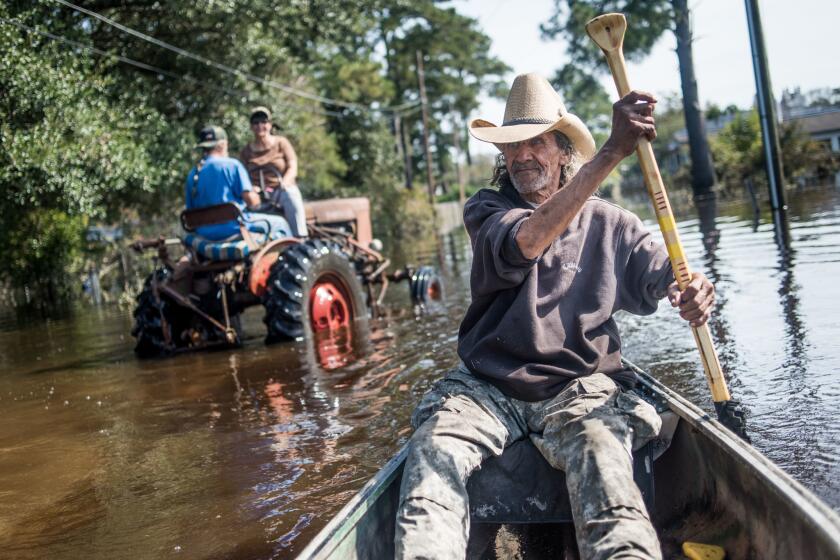 Harvey Wearnes paddles a canoe through a flooded street in his neighborhood on Oct. 15, 2016 in Lumberton, North Carolina.