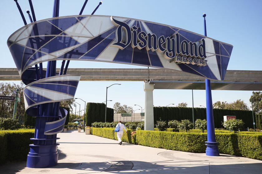 ANAHEIM, CALIFORNIA - SEPTEMBER 30: A person walks into an entrance to Disneyland on September 30, 2020 in Anaheim, California. Disney is laying off 28,000 workers amid the toll of the COVID-19 pandemic on theme parks. (Photo by Mario Tama/Getty Images)