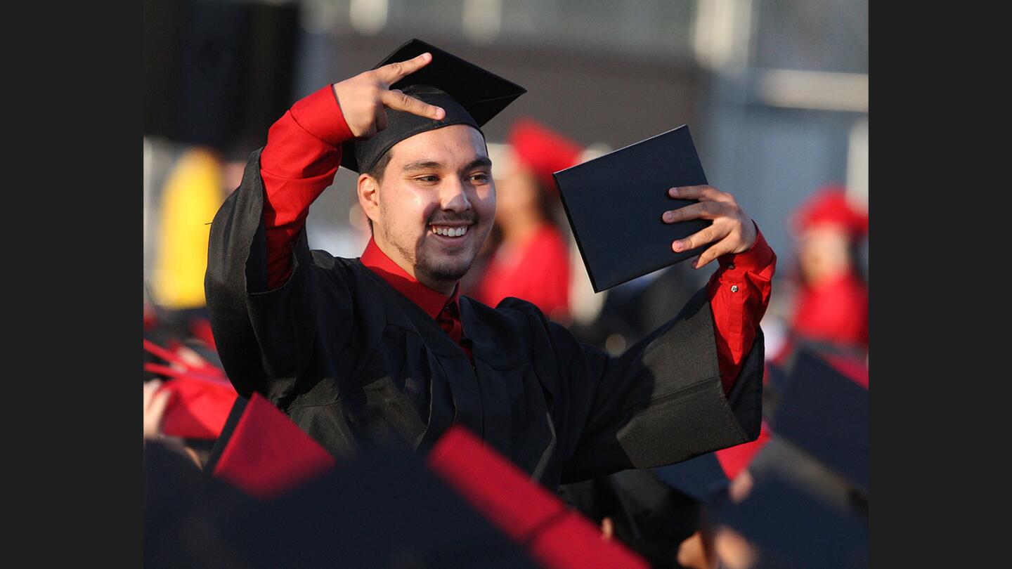 Alejandro Gomez shows off his diploma to a friend after graduating at graduation ceremonies for the class of 2017 at Glendale High School on Thursday, June 1, 2017.