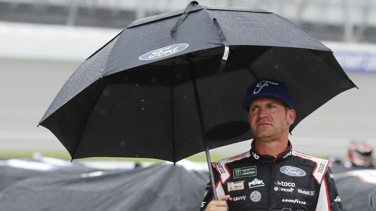 NASCAR driver Clint Bowyer stands on pit row while waiting out a rain delay at Michigan International Speedway on June 9. The postponed race will be run on June 10.