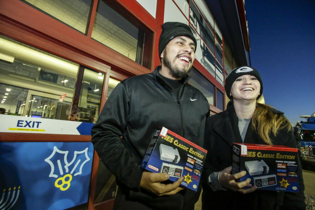 Greg Mayorga, left, and Deysi Flores are jubilant after purchasing one of only 57 units of retro-looking Nintendo NES Classic at Best Buy in Atwater Village.