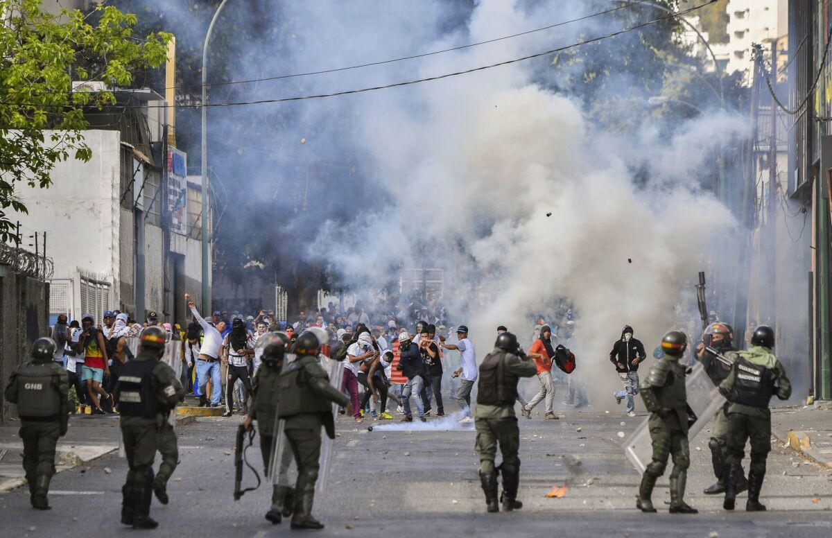 Riot police clash with opposition demonstrators during a protest against the government of President Nicolas Maduro on the anniversary of the 1958 uprising that overthrew the military dictatorship, in Caracas Jan. 23.