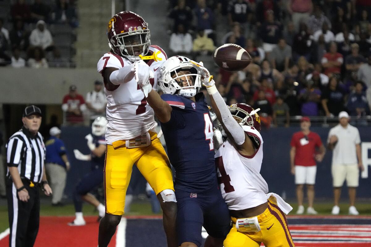 USC defensive backs  Calen Bullock and Max Williams jump and break up a pass intended for Arizona receiver Tetairoa McMillan 