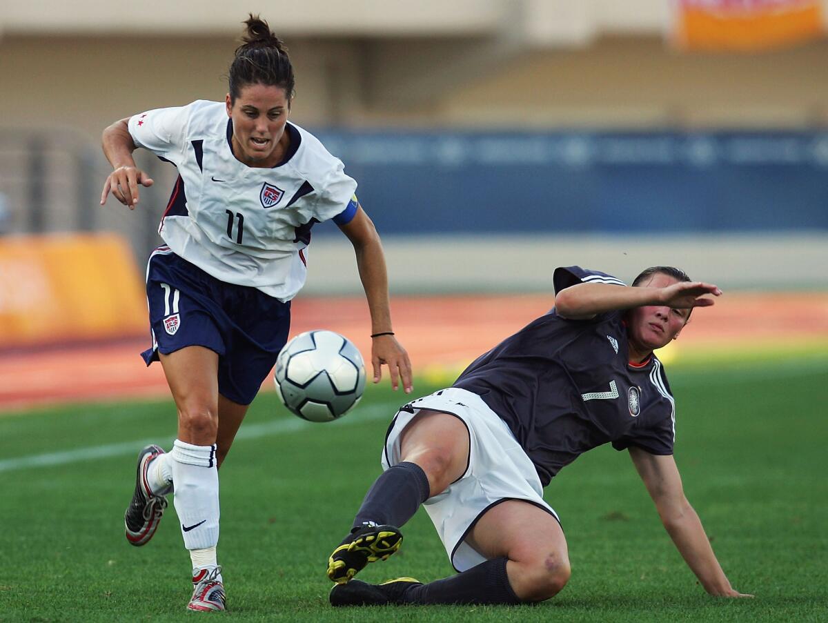 Julie Foudy controls the ball after pushing past Germany's Pia Wunderlich during the 2004 Olympics