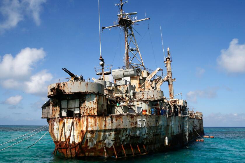 A Philippine Navy ship floats in a shallow region of the South China Sea in 2014. When diplomacy went nowhere and Chinese vessels seized a disputed shoal and then surrounded another reef, Filipino officials took a desperate step: They went to court.