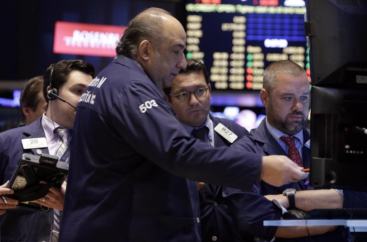 Traders gather around video screens as they work on the floor of the New York Stock Exchange Tuesday. U.S. stock indexes bounced back from a loss the day before.