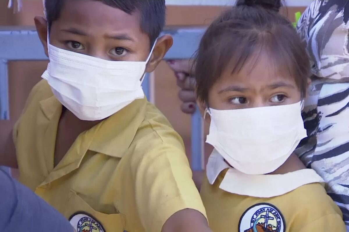 Children wait to get vaccinated at a health clinic in Apia, Samoa, on Nov. 18.