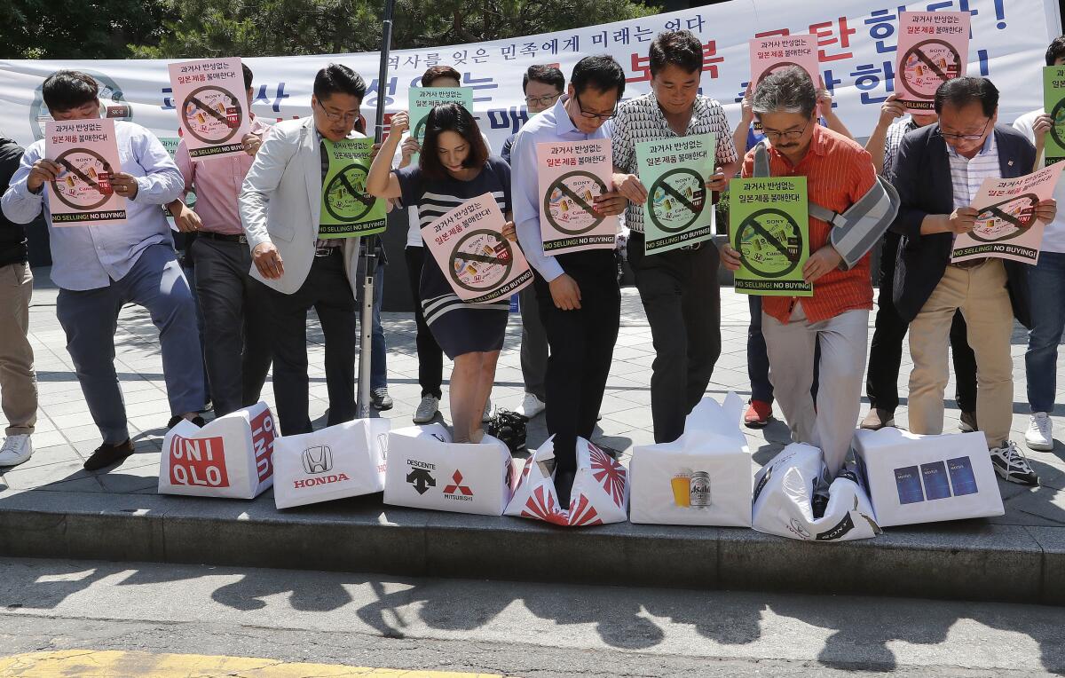 South Korean merchants trample boxes symboling Japanese products during a rally to denounce Japanese government's decision on restricting exports of semiconductor materials to South Korea, in front of the Japanese embassy in Seoul, South Korea on July 5.