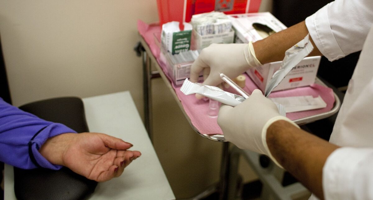 Total spending per patient was 10.3% higher for hospital-owned physician offices compared with doctor-owned organizations, according to a UC Berkeley study. Above, a medical assistant prepares to give a blood test to a patient.