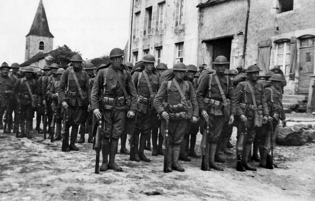 1918: U.S. Army 91st Division troops leave a French village where they had been billeted before heading to the front during the Arnonne-Meuse offensive.