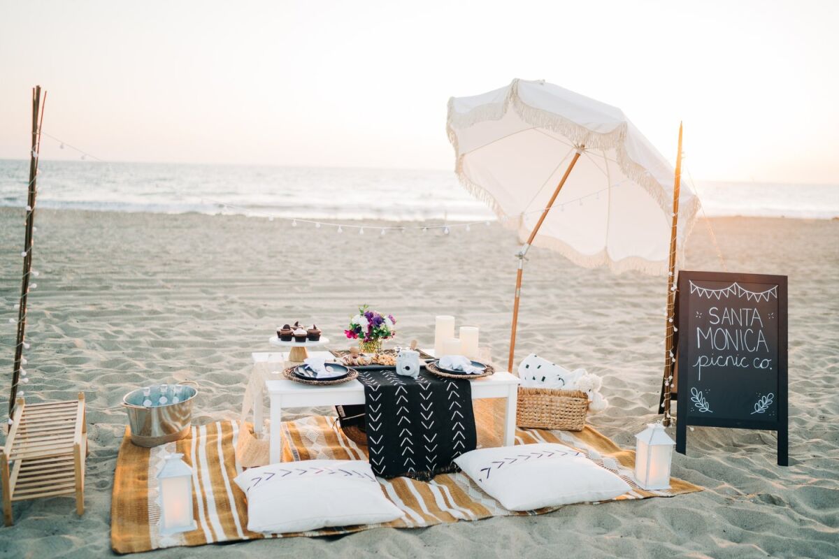 A picnic table with place settings on the beach. 
