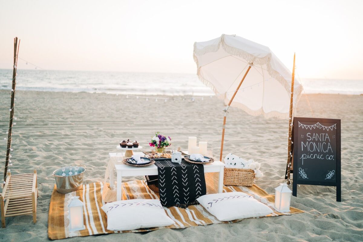 A picnic table with place settings on the beach.