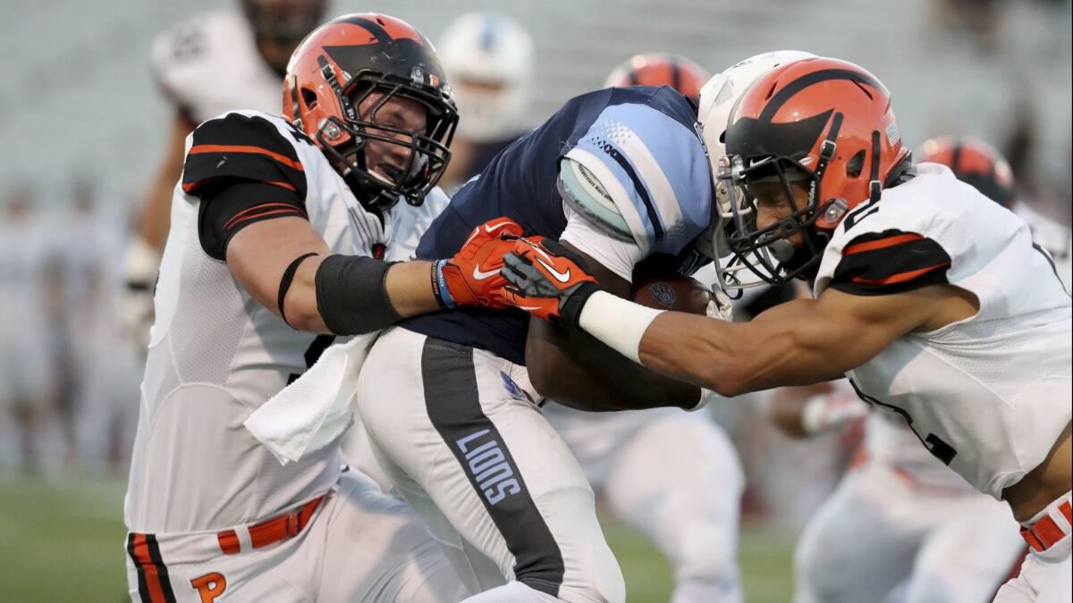 A Columbia University football player is sandwiched between two Princeton players in a recent match-up. A rule change in the Ivy League was associated with a lower rate rate of concussions, researchers found.