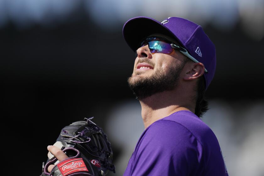 Colorado Rockies first baseman Kris Bryant looks to throw a baseball into the stands during the second inning of a spring training baseball game against the Los Angeles Angels Wednesday, Feb. 28, 2024, in Scottsdale, Ariz. (AP Photo/Ross D. Franklin)